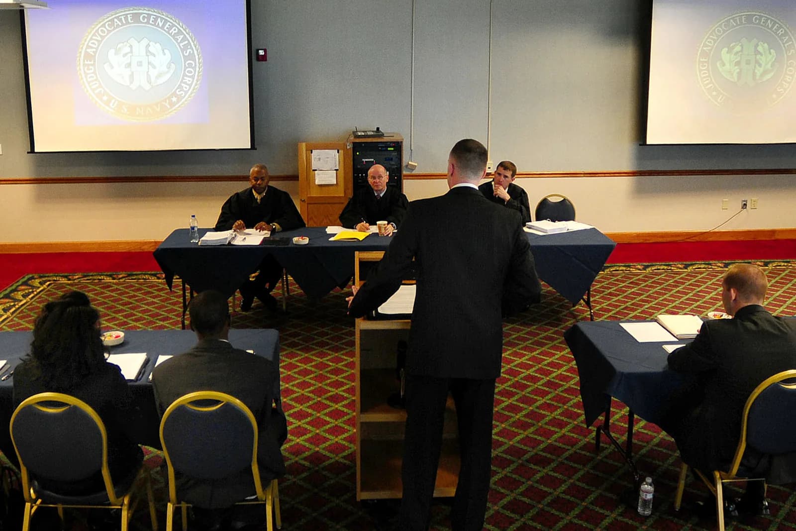 A law student arguing before a panel of judges at a national moot court competition.